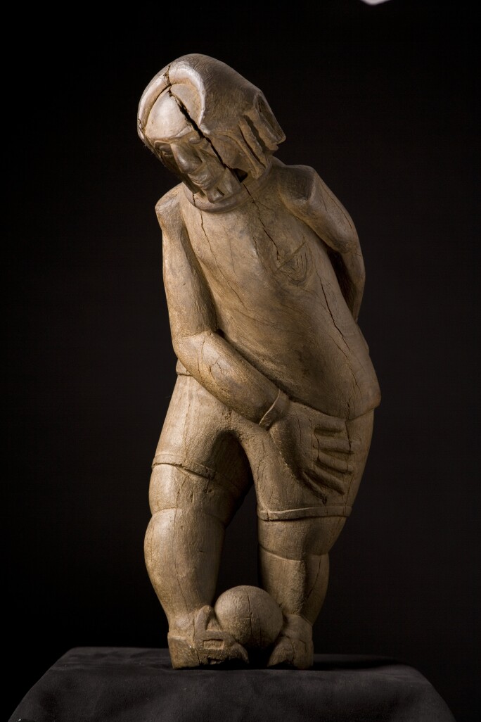 Christ Playing Football, wooden sculpture.