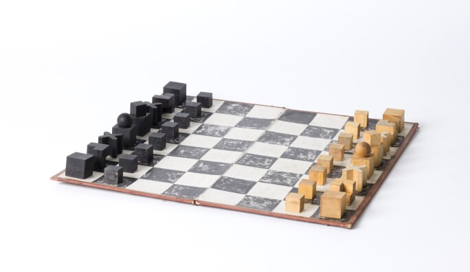 Bauhaus-style chess set with wooden pieces atop of chess board