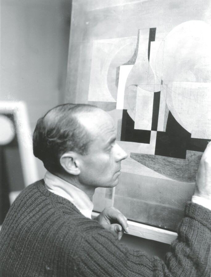 Photograph of Ben Nicholson working on a still life (1929-1935). Front of photograph
